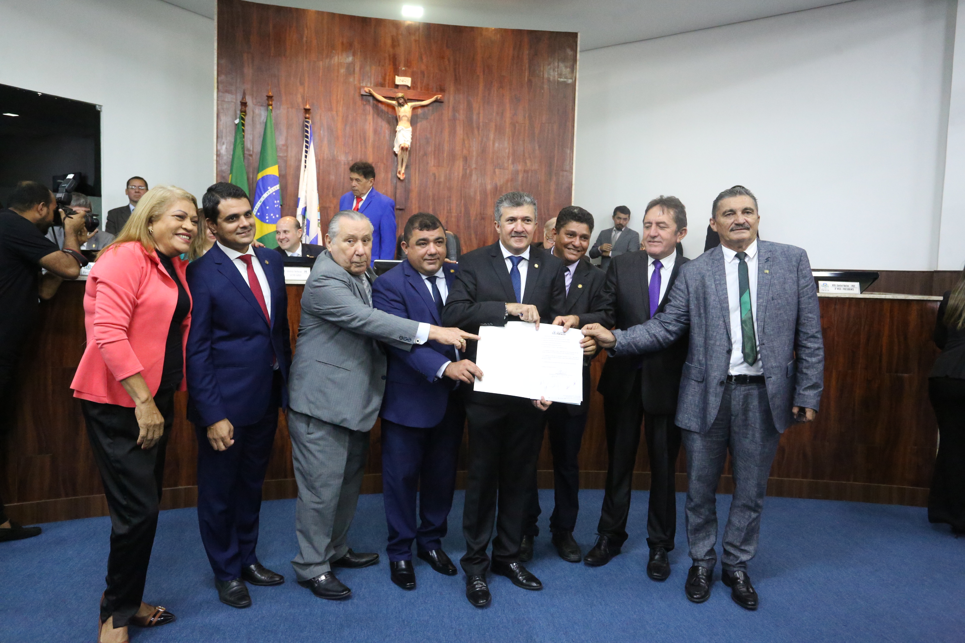 pessoas em pé segurando documento e sorrindo para a foto